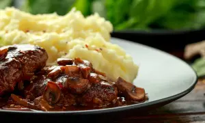 Délicieuses joue de boeuf en sauce avec des champignons, servies avec une purée de pommes de terre onctueuse.