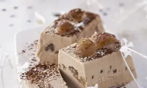 Tranches d'une délicieuse recette buche aux marrons, garnies de marrons glacés et saupoudrées de cacao.