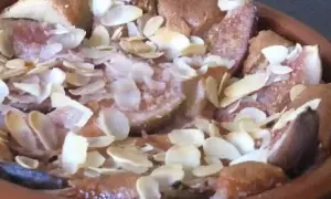 Un délicieux clafoutis aux figues, parsemé d'amandes effilées, sort du four.