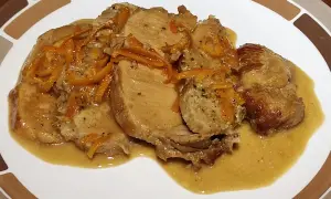 Tranches de roti de porc à l'orange, nappées d'une sauce onctueuse et garnies de zestes d'orange. Un plat savoureux et parfumé.