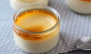 Crème aux œufs on a polka dot cloth, with a spoon nearby. The dessert has a golden, caramelized top.