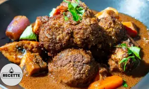 Un plat réconfortant de boeuf miroton recette, avec des morceaux de viande tendres mijotés dans une sauce savoureuse, accompagnés de carottes et d'oignons.