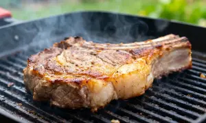 Une succulente basse côte de bœuf au barbecue, fumante et saisie à la perfection sur une grille.