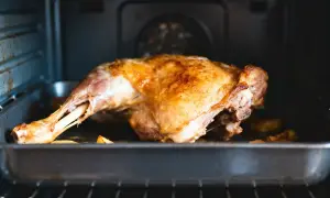 Gigot d'agneau doré, prêt pour la cuisson au four. La peau croustillante promet un délice.