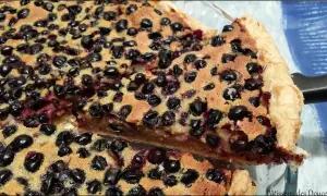 Une part généreuse de tarte aux cassis, garnie de fruits noirs juteux et d'une pâte dorée. Un délice gourmand.