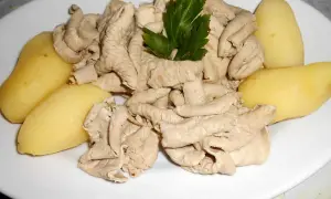Une assiette de fraise de veau, tendres et savoureuses, accompagnée de pommes de terre vapeur et d'une touche de persil frais.