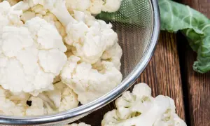 Chou-fleur frais coupé en bouquets dans une passoire, prêt pour la cuisson. Eau froide ou chaude, le choix dépend de la recette.
