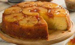 Un délicieux gâteau moelleux ananas, avec des tranches d'ananas caramélisées sur le dessus, une part a été coupée.