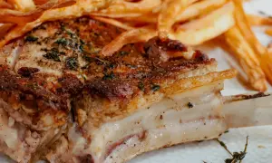 Une côte de veau au four, dorée et savoureuse, accompagnée de frites croustillantes. Un plat réconfortant pour un repas gourmand.