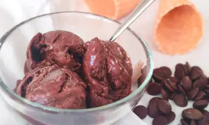 Un bol de semifreddo chocolat, avec des pépites de chocolat et des cornets à glace en arrière-plan.