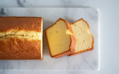Un délicieux quatre-quarts doré, coupé en tranches sur une planche de marbre.