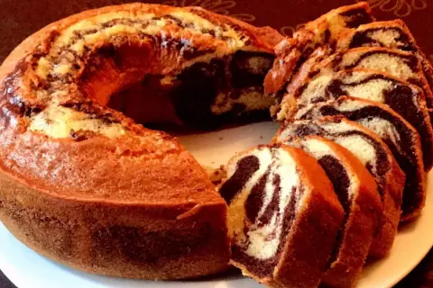 Un délicieux gâteau marbré, coupé en tranches, révèle ses tourbillons de chocolat et de vanille.