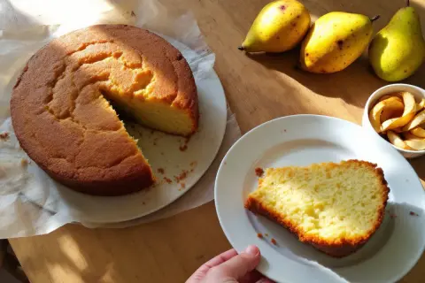Un délicieux gâteau à la banane, encore tiède, avec des poires et des chips de pomme sur une table en bois.