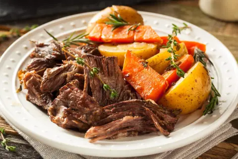 Un plat de bœuf effiloché, carottes et pommes de terre rôties, garni de thym frais. Une belle inspiration pour une recette bœuf carottes Laurent Mariotte.