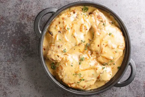 Côtes de porc onctueuses dans une sauce crémeuse aux oignons, garnies de thym frais. Une délicieuse recette côte de porc au four.