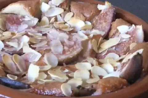 Un délicieux clafoutis aux figues, parsemé d'amandes effilées, sort du four.