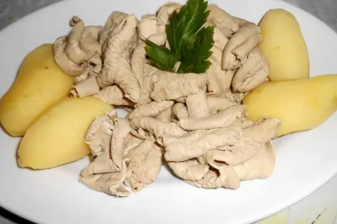 Une assiette de fraise de veau, tendres et savoureuses, accompagnée de pommes de terre vapeur et d'une touche de persil frais.