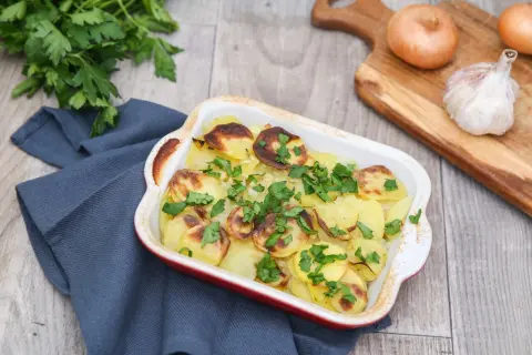 Pommes boulangères dorées et garnies de persil frais, prêtes à être dégustées. La meilleure recette pour un plat réconfortant.