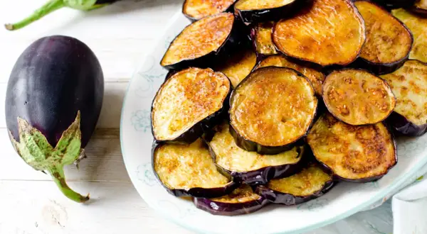 Aubergines coupées en rondelles, dorées et prêtes à être dégustées. Le temps de cuisson aubergine à l'eau est court pour un plat savoureux.