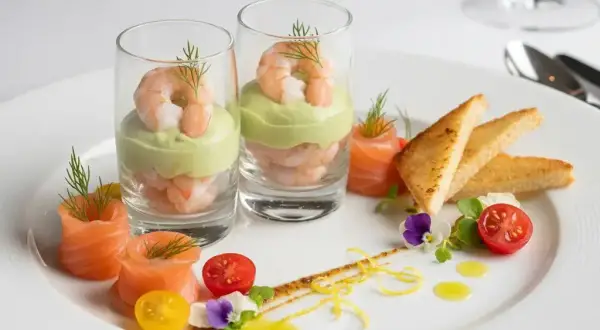 Une élégante entrée froide : crevettes et avocat en verrine, saumon roulé, toasts grillés et garnitures fraîches.