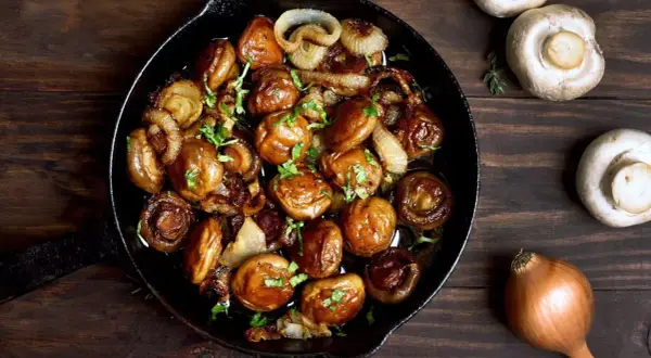 Poêlée de champignons et oignons caramélisés, une délicieuse cuisson des cèpes, garnie de persil frais.