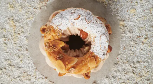 Un Paris-Brest gourmand, garni de crème onctueuse et d'amandes effilées. Une recette qui fait saliver !