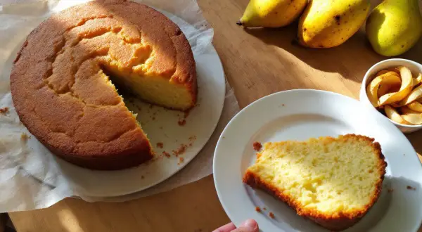 Un délicieux gâteau à la banane, encore tiède, avec des poires et des chips de pomme sur une table en bois.