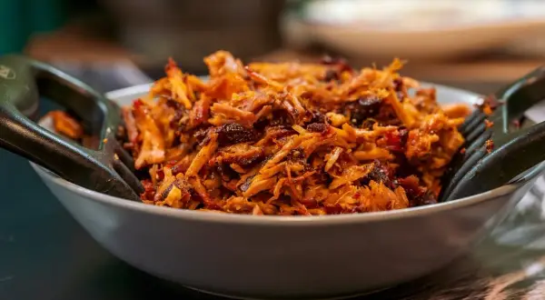 Un plat appétissant d'effiloché de porc, prêt à être dégusté. Une recette facile pour un repas savoureux.