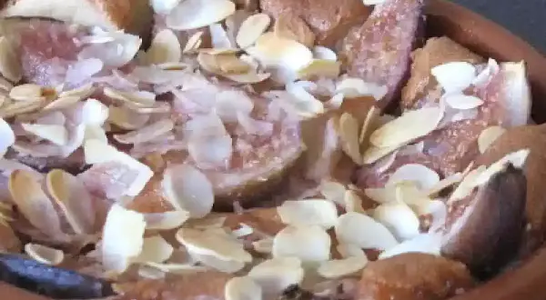 Un délicieux clafoutis aux figues, parsemé d'amandes effilées, sort du four.
