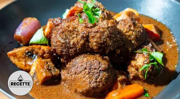 Un plat réconfortant de boeuf miroton recette, avec des morceaux de viande tendres mijotés dans une sauce savoureuse, accompagnés de carottes et d'oignons.