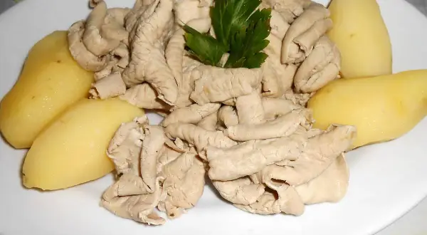 Une assiette de fraise de veau, tendres et savoureuses, accompagnée de pommes de terre vapeur et d'une touche de persil frais.
