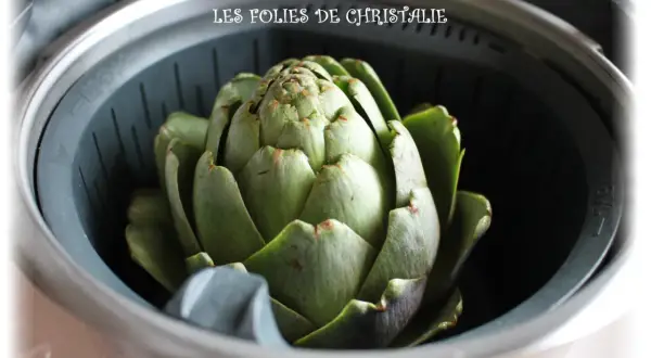 Un gros artichaut vert est prêt pour la cuisson vapeur. Le temps de cuisson vapeur de l'artichaut est bientôt terminé.