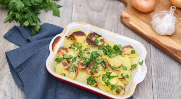 Pommes boulangères dorées et garnies de persil frais, prêtes à être dégustées. La meilleure recette pour un plat réconfortant.