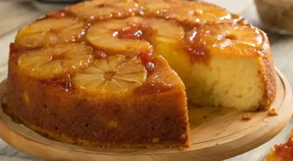 Un délicieux gâteau moelleux ananas, avec des tranches d'ananas caramélisées sur le dessus, une part a été coupée.