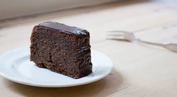 Tranche de fondant au chocolat Laurent Mariotte, nappée d'un glaçage brillant, sur une assiette blanche. Une fourchette est posée à côté.