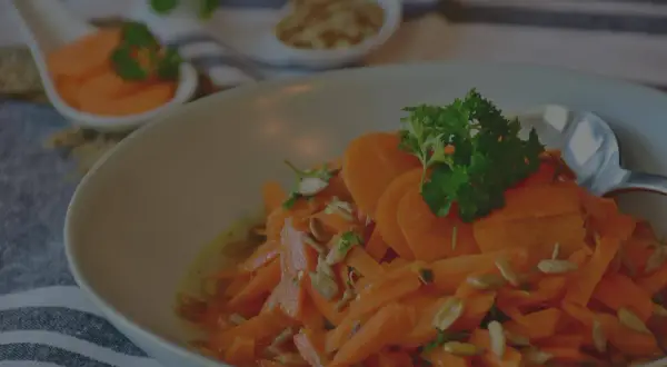 Carottes Vichy grand-mère, une salade fraîche et colorée, garnie de persil et de graines de tournesol. Un délice simple et savoureux.