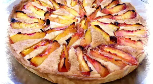 Tarte aux nectarines et crème d'amande, un délice doré et fruité, prêt à être dégusté.