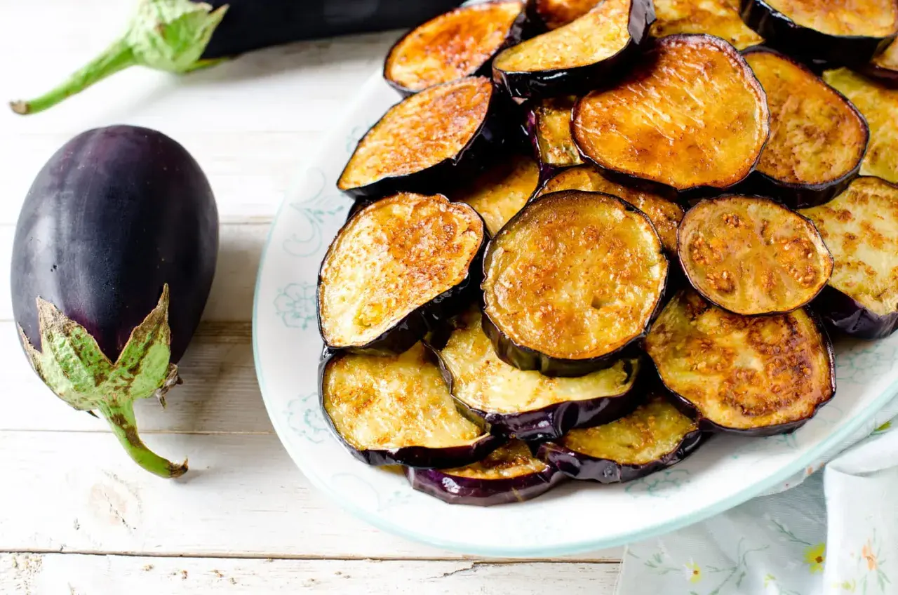 Aubergines coupées en rondelles, dorées et prêtes à être dégustées. Le temps de cuisson aubergine à l'eau est court pour un plat savoureux.