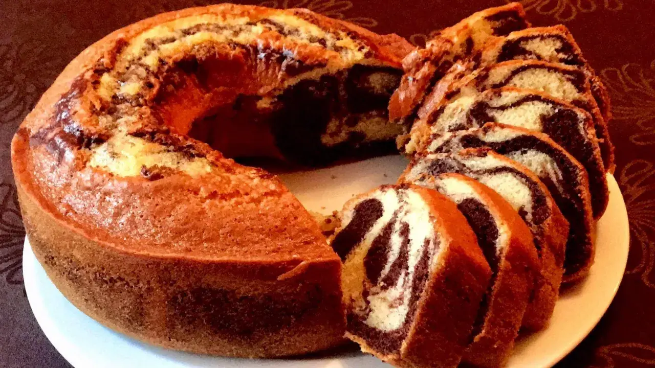 Un délicieux gâteau marbré, coupé en tranches, révèle ses tourbillons de chocolat et de vanille.