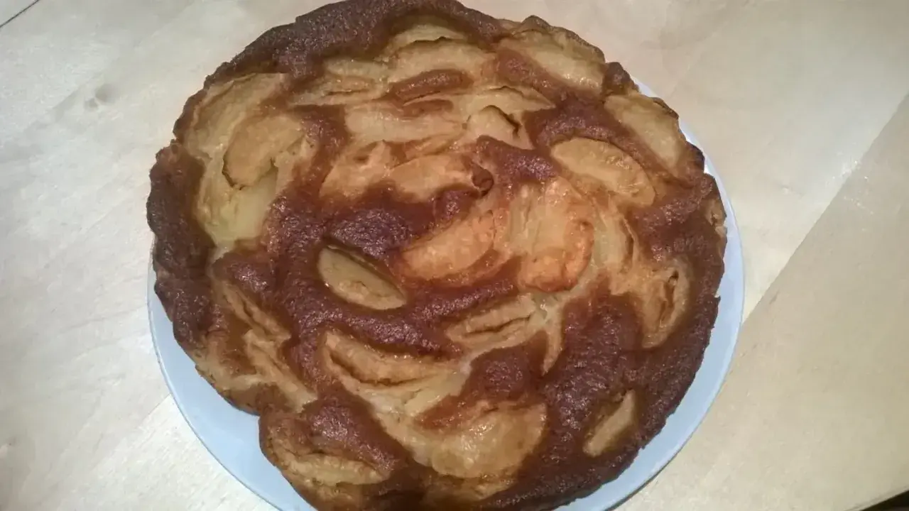 Gâteau aux pommes doré, un délice sans sucre, avec des fruits caramélisés sur le dessus.