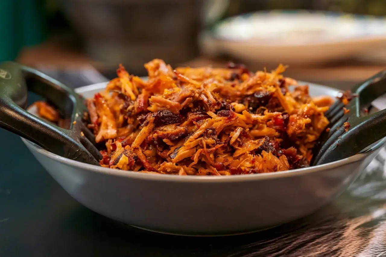 Un plat appétissant d'effiloché de porc, prêt à être dégusté. Une recette facile pour un repas savoureux.