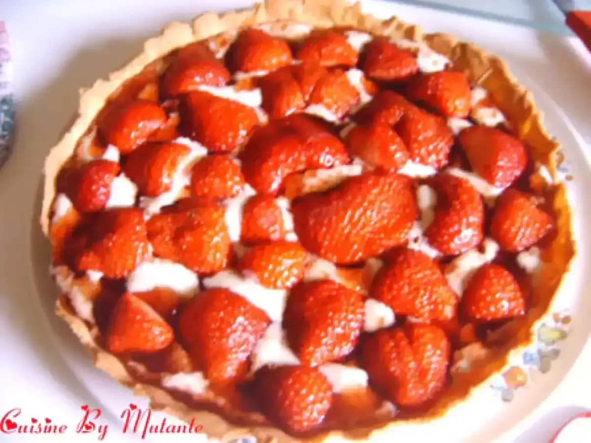 Une délicieuse tarte aux fraises, garnie de fruits rouges frais et d'une crème onctueuse, prête à être dégustée.