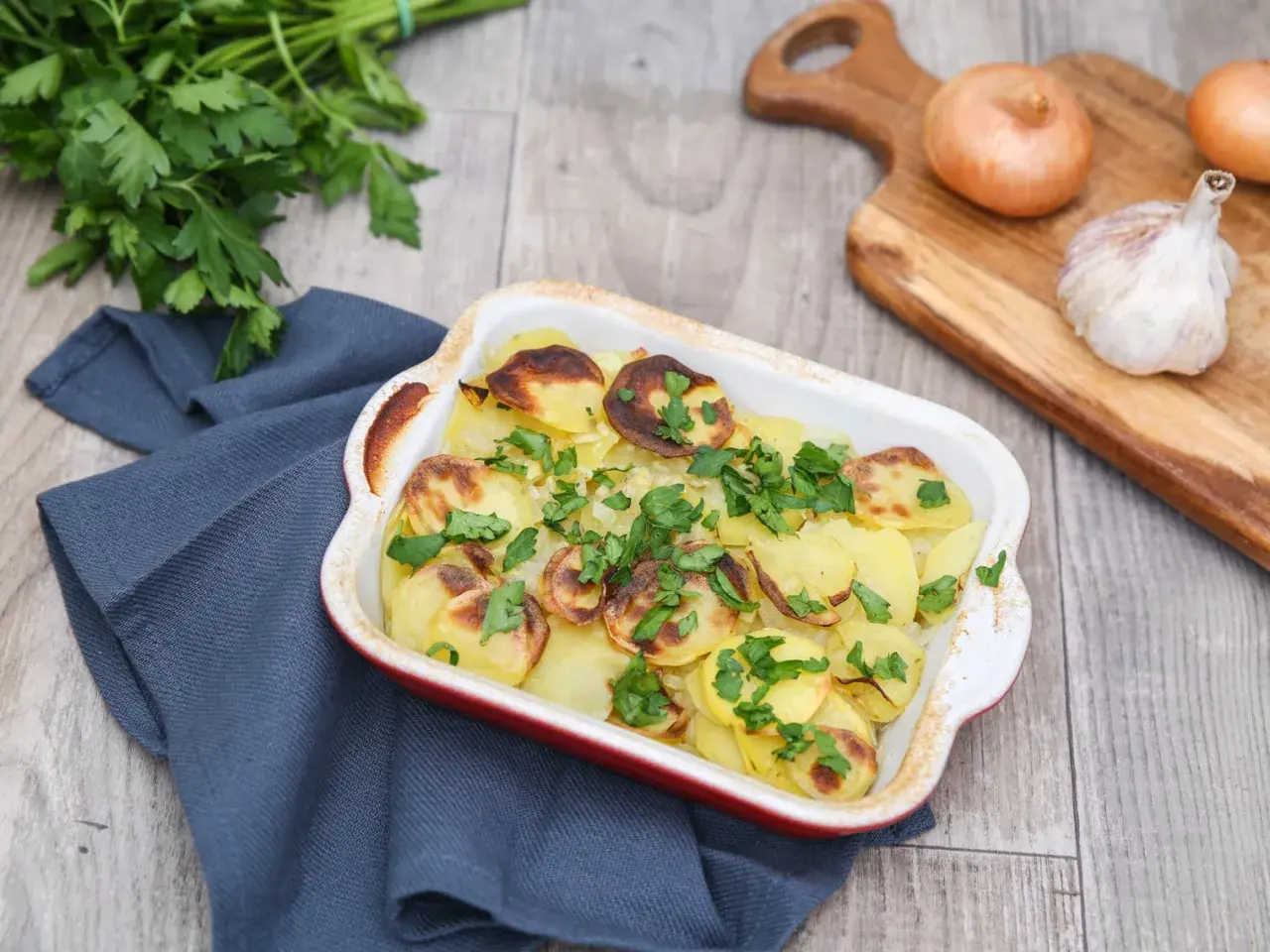 Pommes boulangères dorées et garnies de persil frais, prêtes à être dégustées. La meilleure recette pour un plat réconfortant.