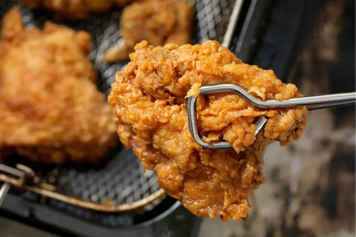Une cuisse de poulet croustillante, dorée et appétissante, tout juste sortie de l'air fryer.