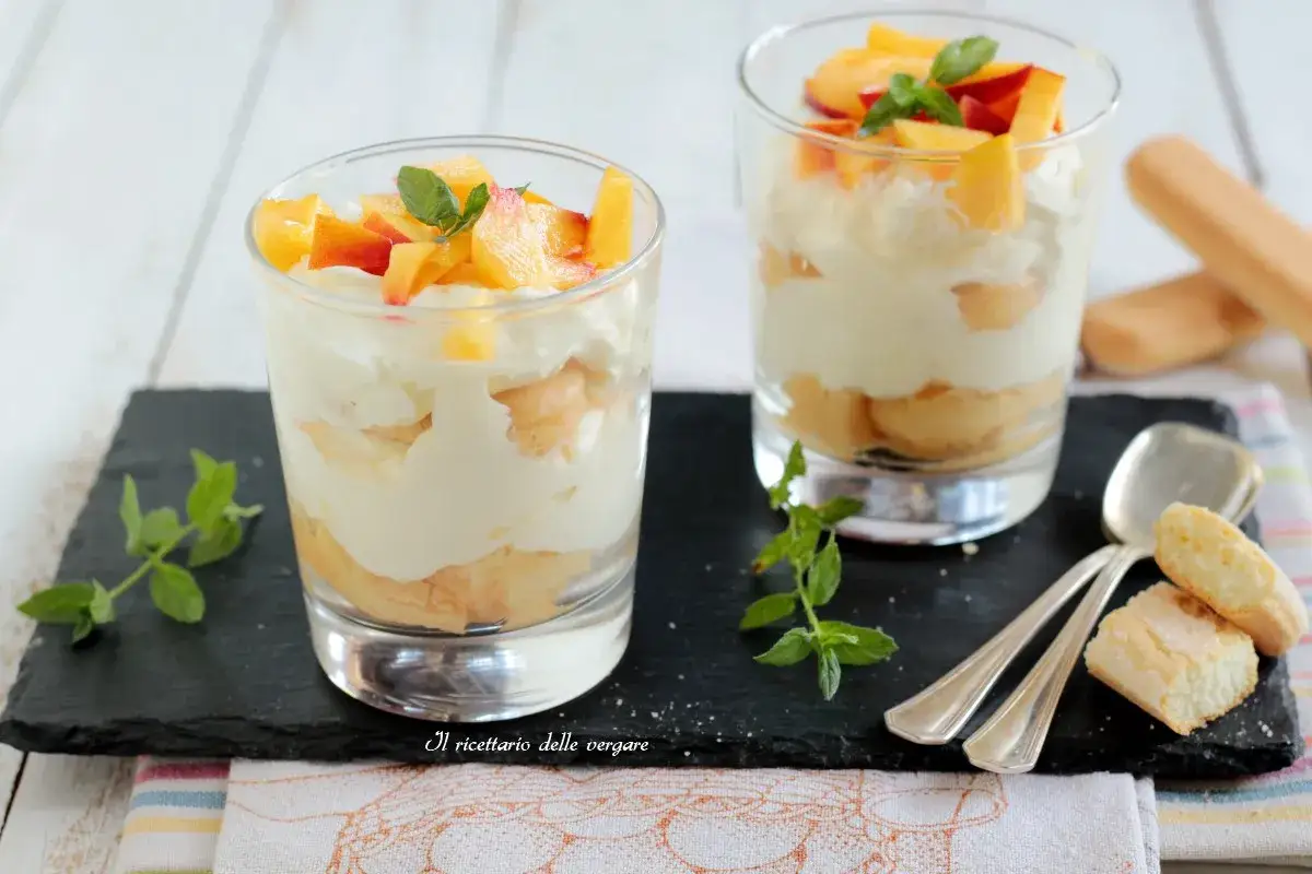 Deux verrines de tiramisu p&ecirc;che, garnies de fruits frais et de feuilles de menthe. Un d&eacute;lice estival.