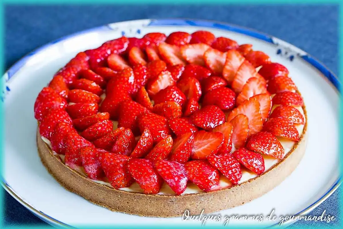 Tarte aux fraises fraîchement préparée, garnie de fruits rouges éclatants sur une crème onctueuse. Un délice visuel et gustatif.