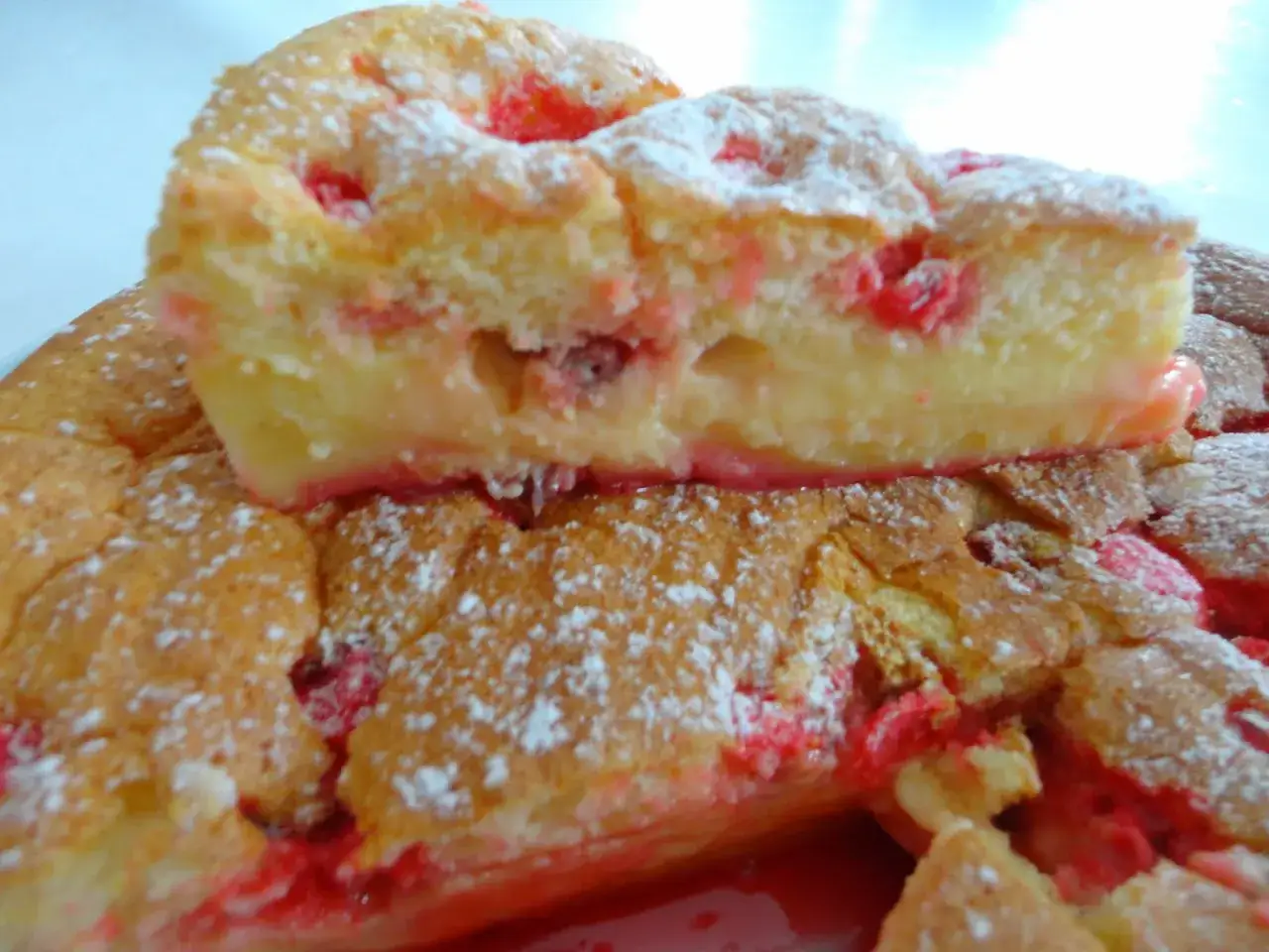 Gâteau moelleux aux pralines roses, saupoudré de sucre glace.