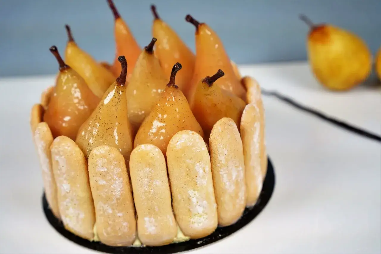 Charlotte aux poires poch&eacute;es, une recette gourmande. Des poires dor&eacute;es et brillantes, entour&eacute;es de biscuits &agrave; la cuill&egrave;re.