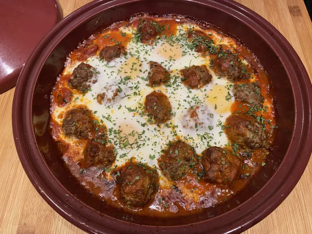 Un plat de tajine kefta aux &oelig;ufs poch&eacute;s, garni de persil frais. Un d&eacute;lice savoureux et r&eacute;confortant.
