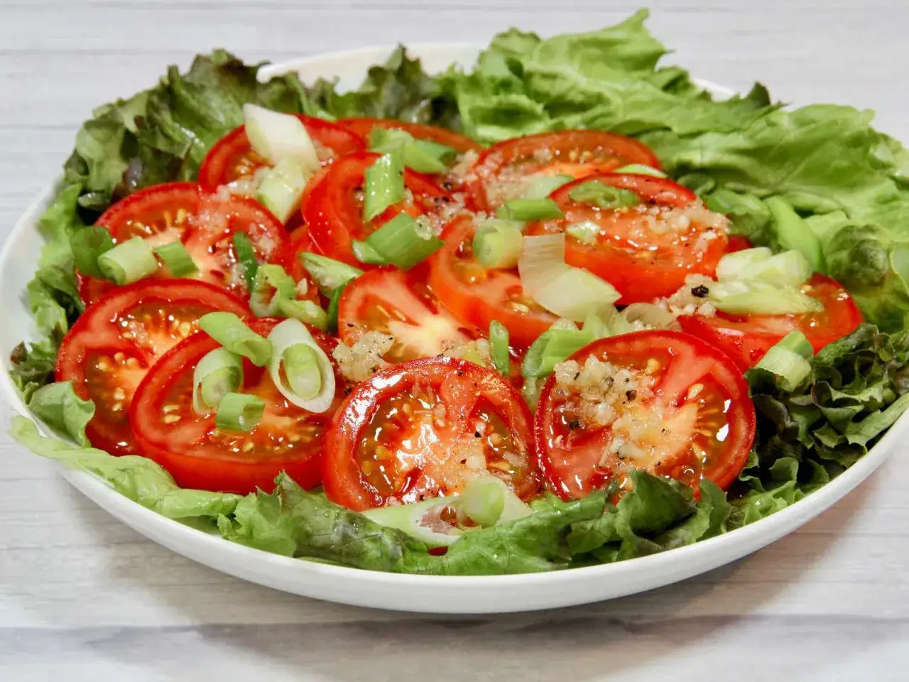 Salade de tomates fra&icirc;ches, oignons verts et laitue, parfaite pour manger tomate le soir.